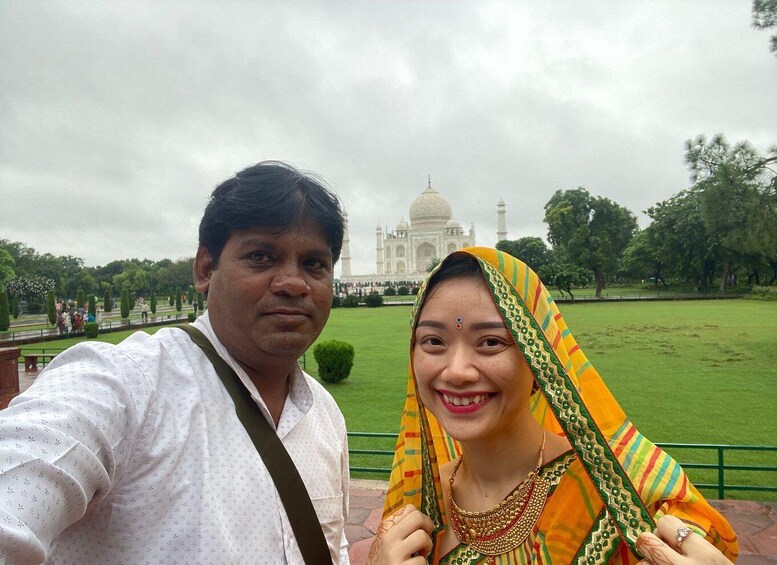 A couple taking a selfie with the Taj Mahal in the background. 2
