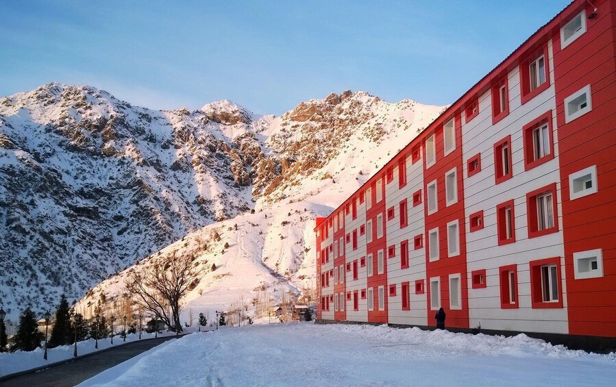 A red and white building with snow-covered mountains in the background. 4