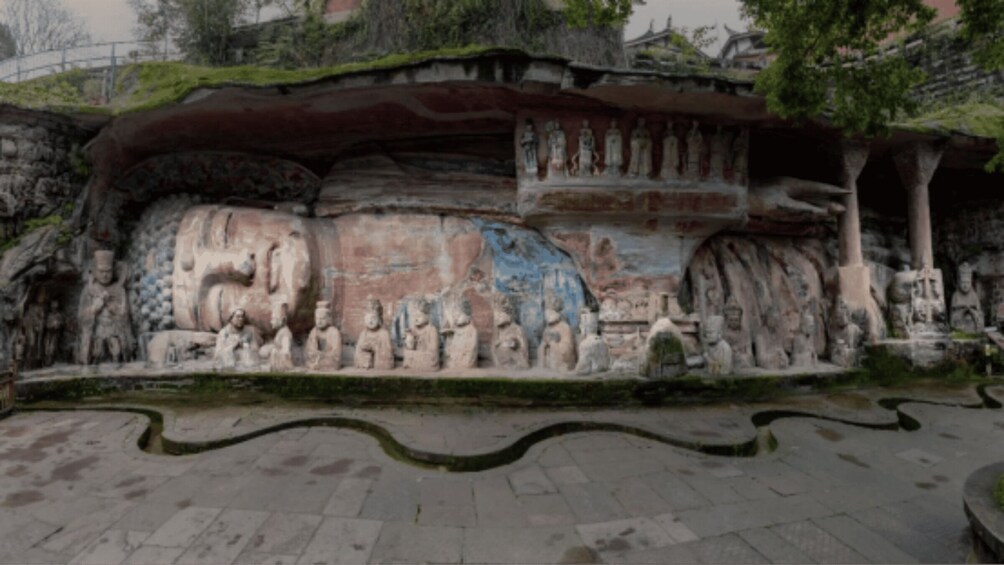 A large rock face with ancient carvings and statues. 3