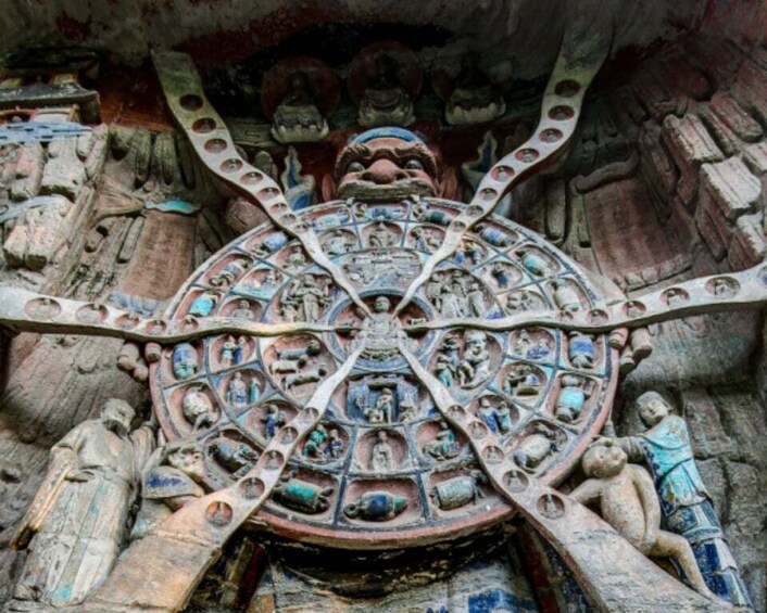 A detailed stone carving with a central circular motif surrounded by figures and patterns. 4
