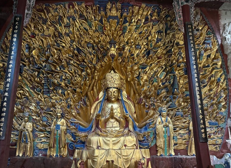 A large golden Buddha statue surrounded by numerous smaller golden figures, with intricate designs and inscriptions on the surrounding walls. 1