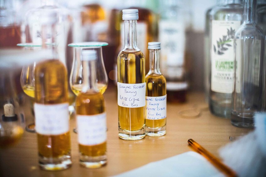 Several glass bottles with labels on a wooden surface. 2