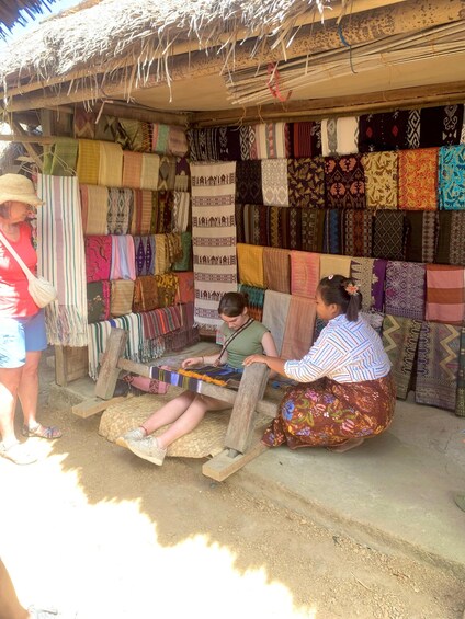 A market stall with colorful textiles and a person weaving. 5