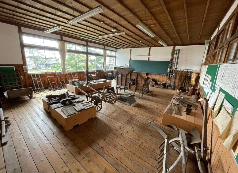 A workshop with wooden floors, large windows, and various tools and equipment. 4
