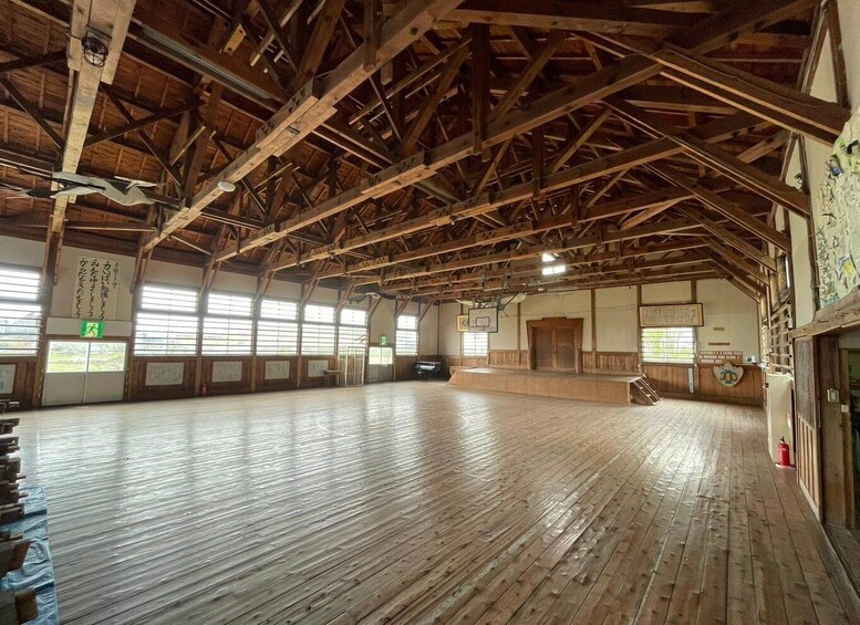 A spacious indoor area with wooden beams and a polished wooden floor. 5
