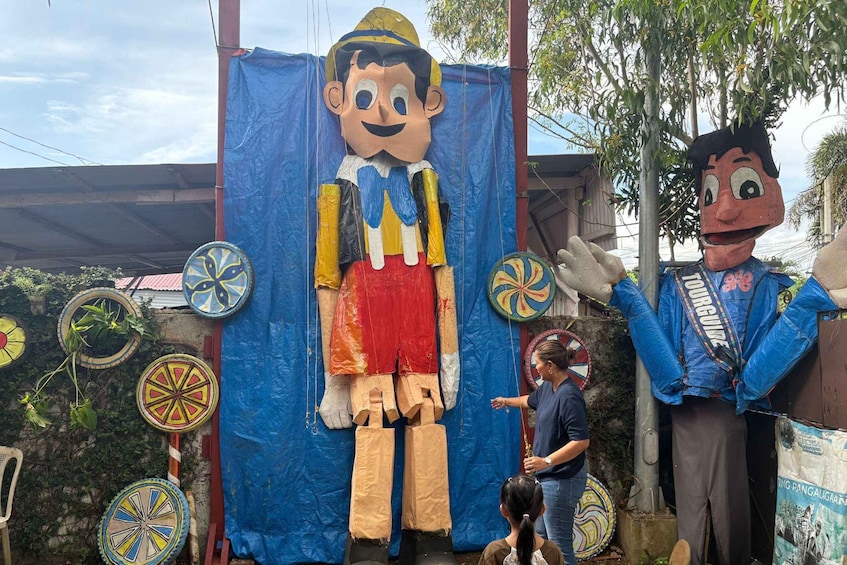 A large cartoon character figure, a person in a blue costume, and a child. 3