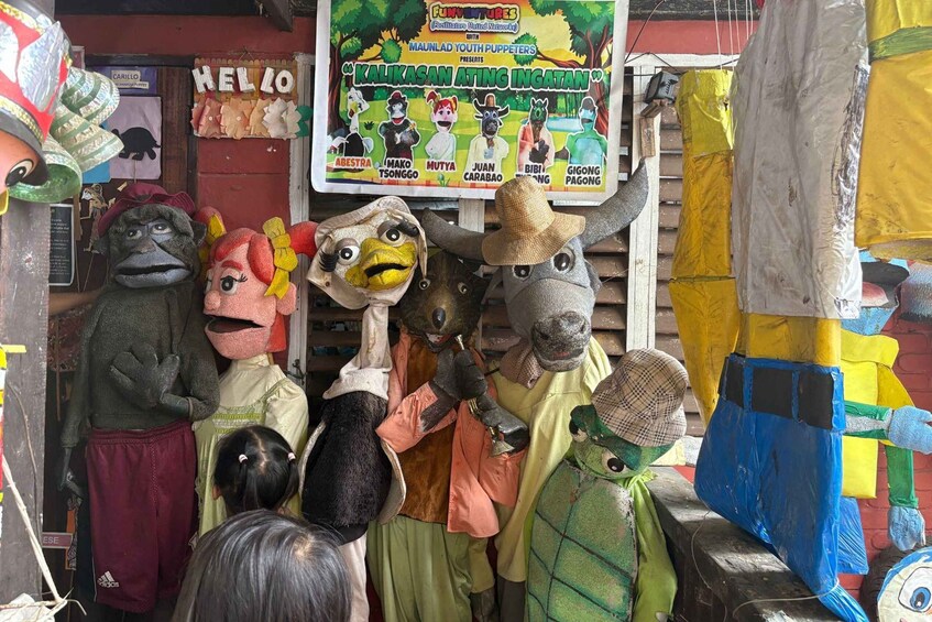 A puppet display with various characters and a signboard. 4