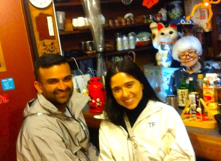 A person in a white jacket with a logo, a red fire extinguisher, and shelves with various items including a toy figure. 4