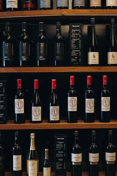 A wine cellar with various bottles of wine on shelves. 4