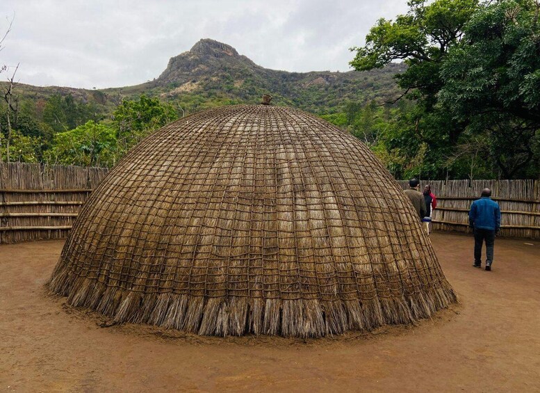 A traditional thatched hut with a natural landscape in the background. 2