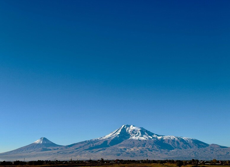 A snow-capped mountain range under a clear blue sky. 1
