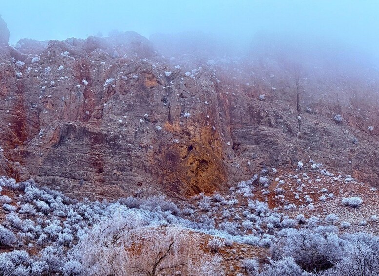 A rugged mountainous landscape with sparse vegetation and rocky cliffs. 4