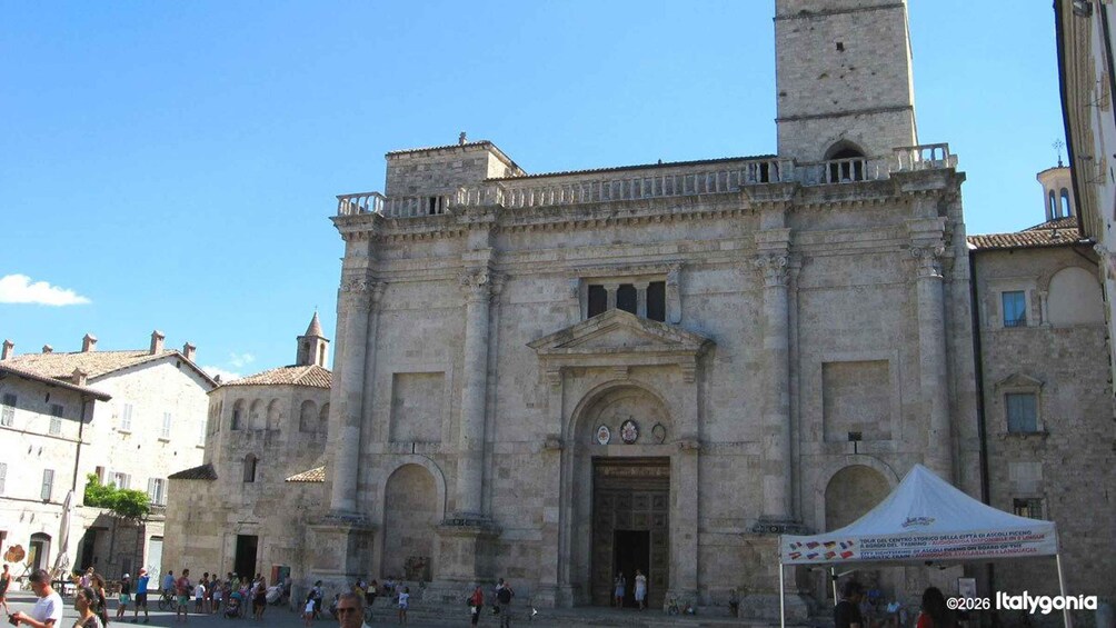A historic stone building with a central entrance and a bell tower. 3
