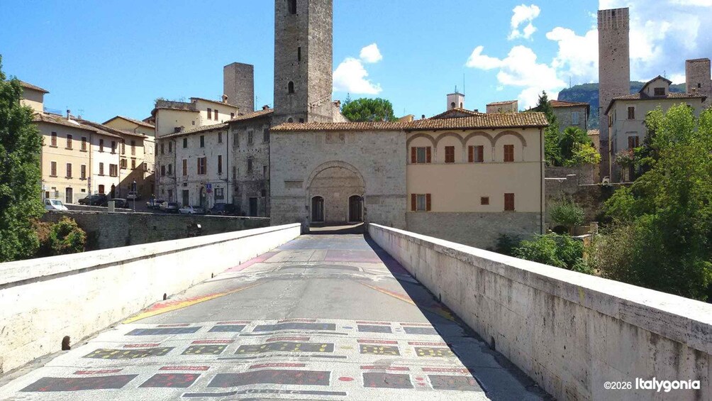 A bridge with a tiled walkway leading to a historic building with towers. 5