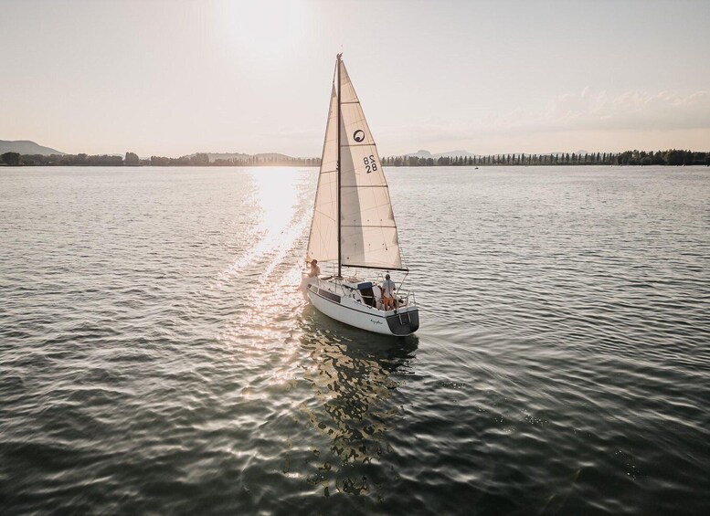 A sailboat on calm water with a clear sky. 1
