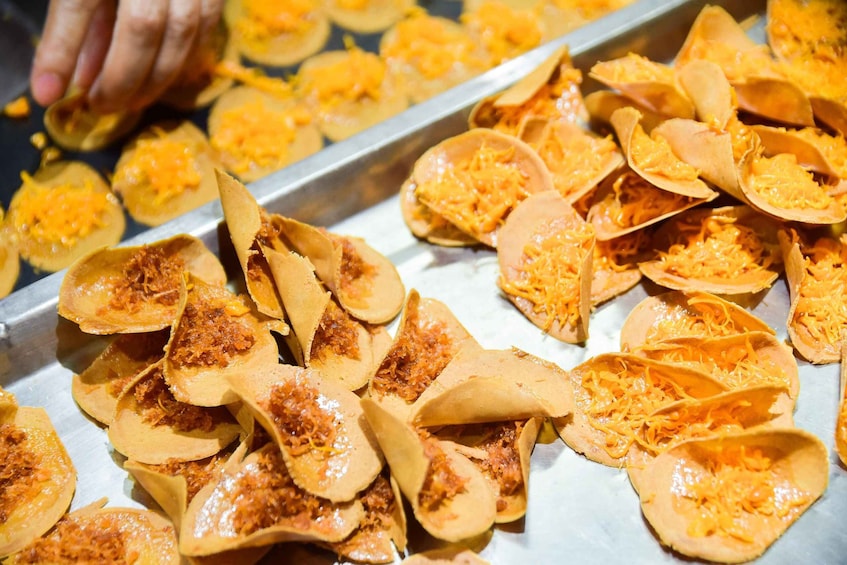 Tortillas filled with cheese and possibly a red sauce, arranged on a metal tray. 5