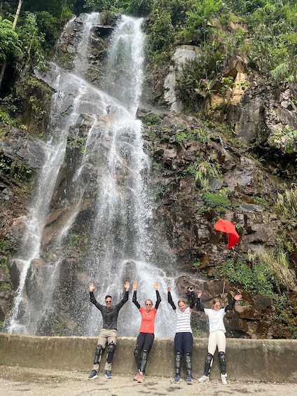 A waterfall cascading down a rocky cliff surrounded by greenery. 1