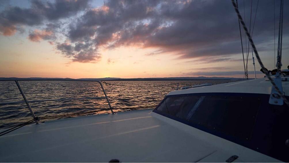 A boat on calm waters during sunset with a clear sky and distant land. 2