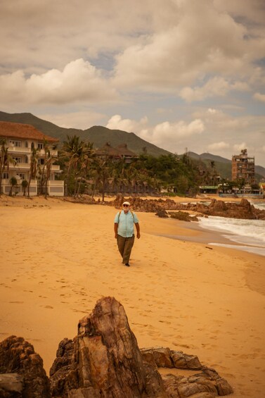 A sandy beach with footprints, palm trees, and buildings in the background. 4