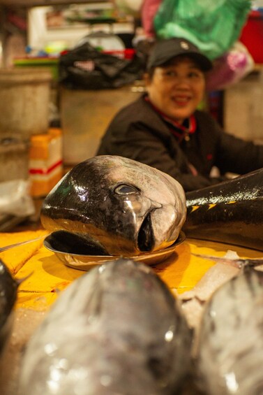 A fish head on a table with a person in the background. 2