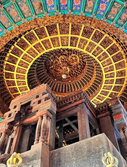 A detailed ceiling with intricate carvings and a central circular design. 3