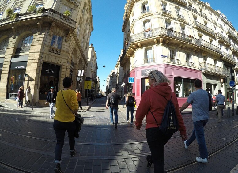 A busy urban street with pedestrians, vintage shops, and classic architecture. 4