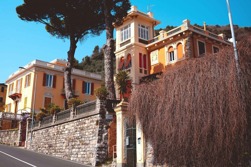 A historic building with a stone wall and a tree in front. 2