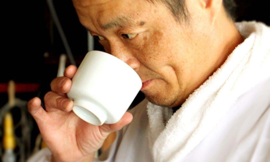 A person holding a white cup. 5