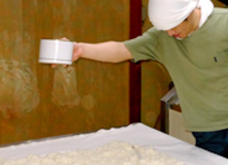 A person in a green shirt pouring a white substance onto a white surface. 2
