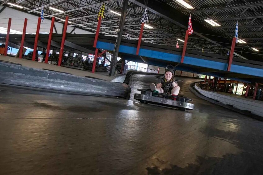 A go-kart track with a person in a go-kart. 1