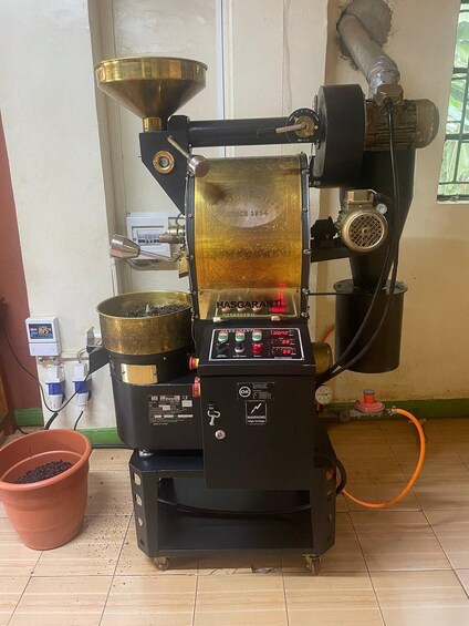 A coffee roaster with a digital display, control panel, and a hopper filled with coffee beans. 3