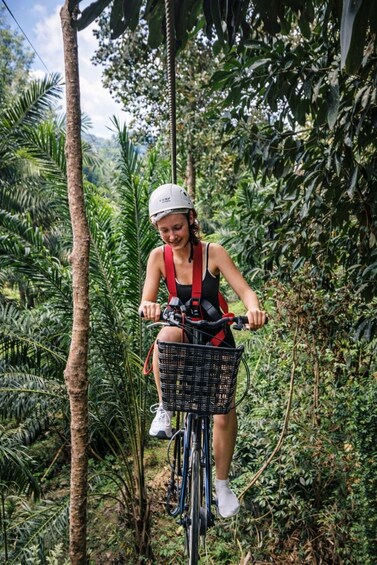 A person riding a bicycle through a dense, tropical forest. 5