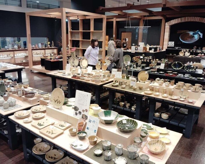 A pottery shop with various ceramic items displayed on tables. 1