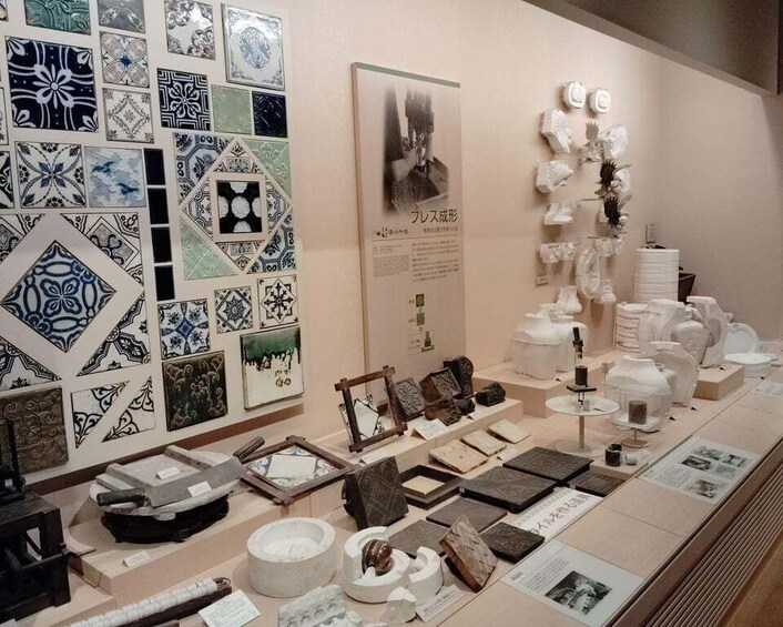 A display of ceramic tiles, pottery, and sculptures in an art exhibit. 5