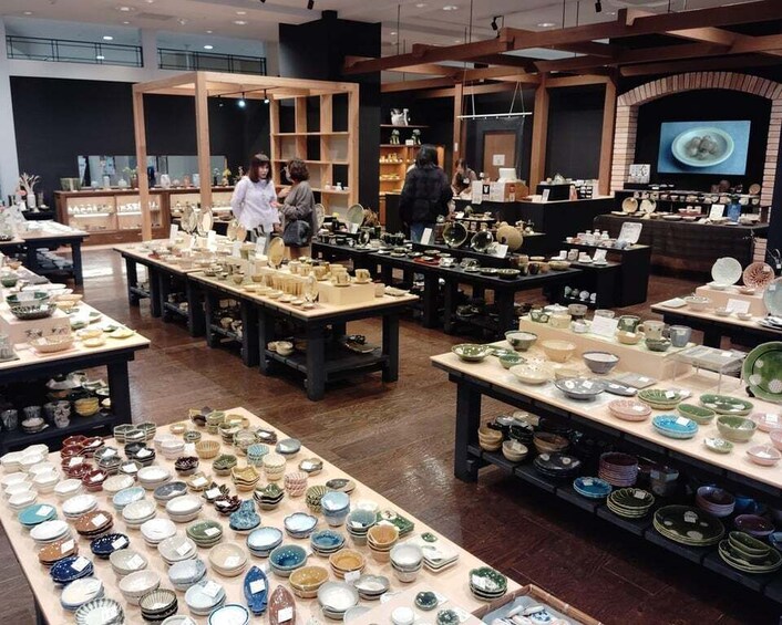 A store with various ceramic dishes and pottery displayed on tables. 3