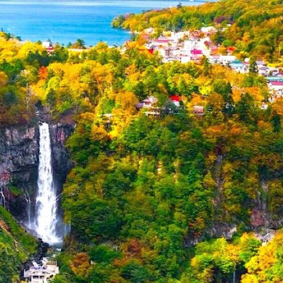 A waterfall surrounded by autumn-colored trees and a coastal village. 2