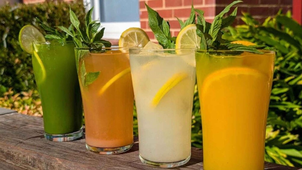 Four glasses of iced beverages with mint leaves and lemon slices. 4