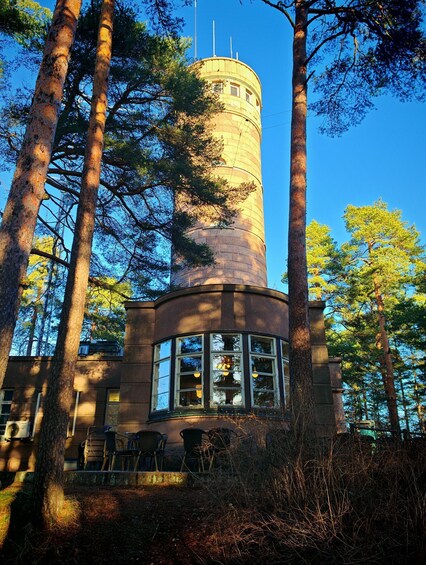 A tower with a cylindrical shape, surrounded by tall trees. 4