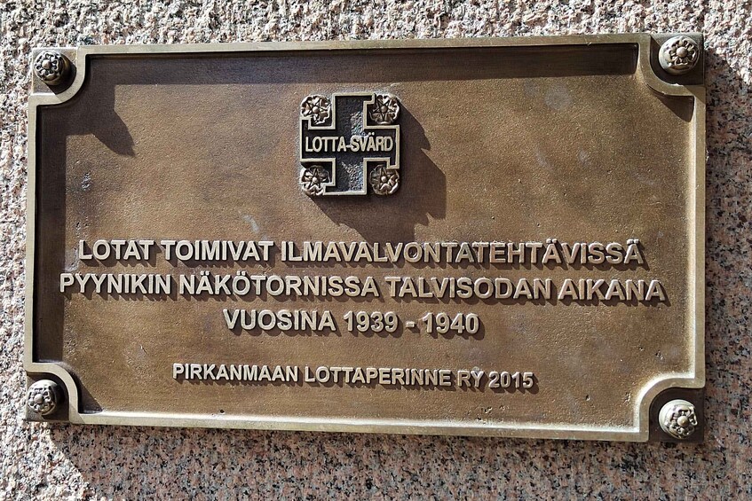 A commemorative plaque mounted on a wall with inscriptions in a foreign language, likely commemorating a historical event or person. 5