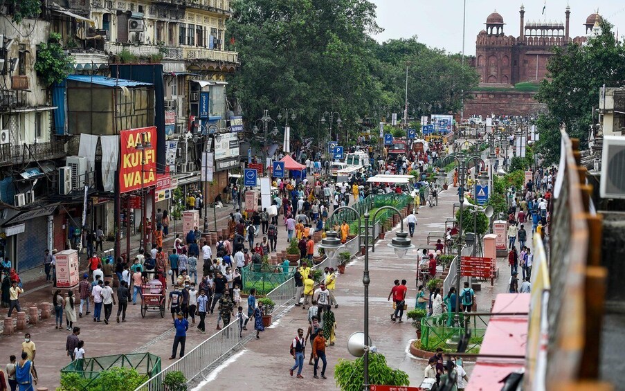 A busy urban street with pedestrians, vehicles, and various shops. 4