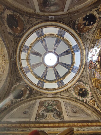 A domed ceiling with intricate frescoes and a central circular window. 3