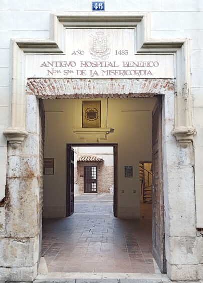 An entrance to the Antigo Hospital Benefico with a sign indicating its establishment in 1483. 4