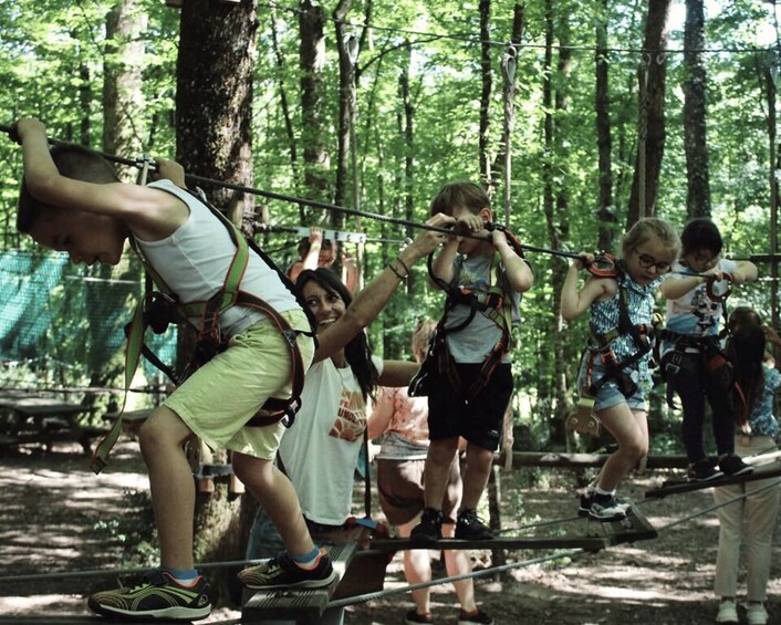People on a rope bridge in a forest. 5