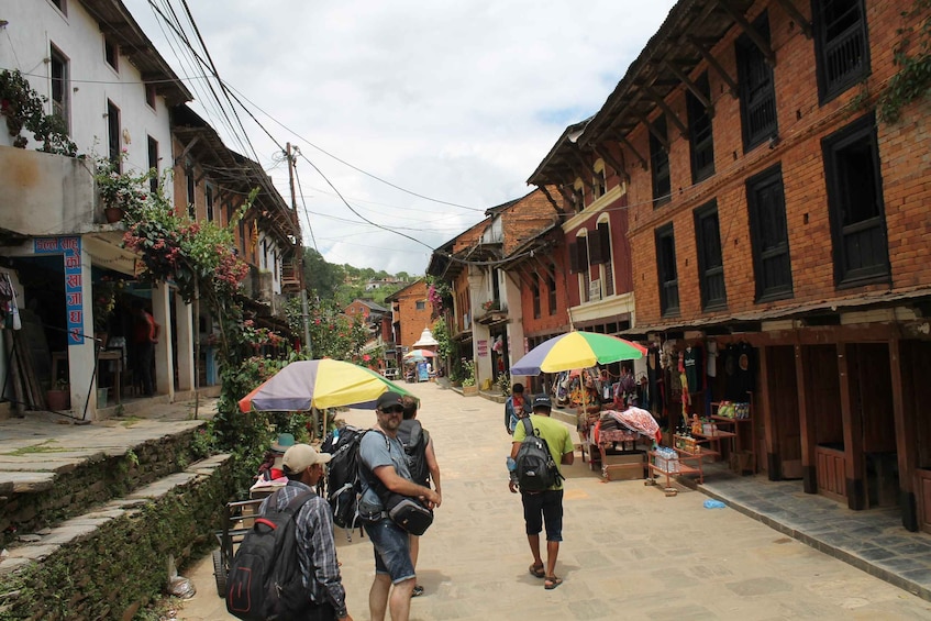 A narrow street lined with traditional buildings, some with shops on the ground floor. 5