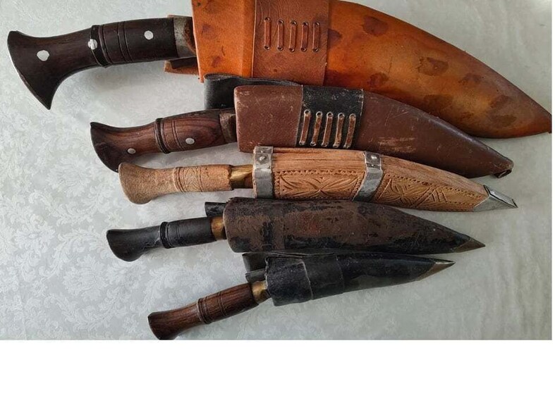 A collection of antique knives with wooden handles and metal blades, some with leather sheaths. 1