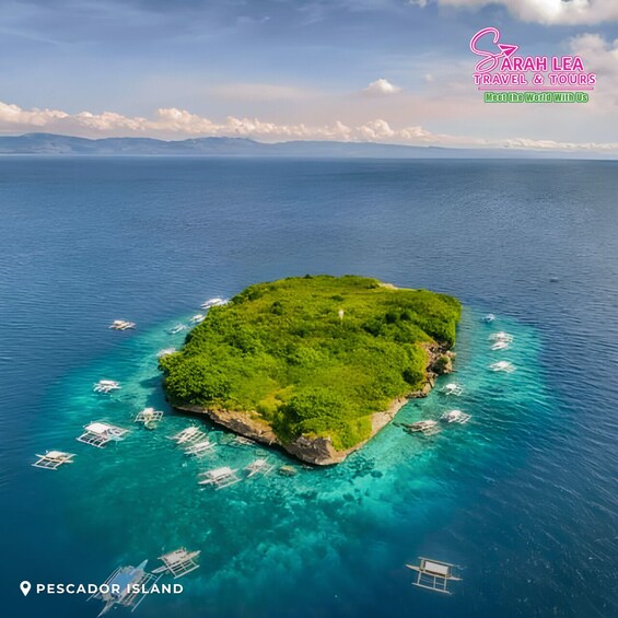A lush green island surrounded by clear blue waters with several boats anchored nearby. 3