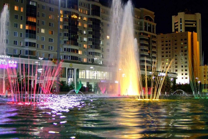 A nighttime fountain display with water jets and colorful lights. 2