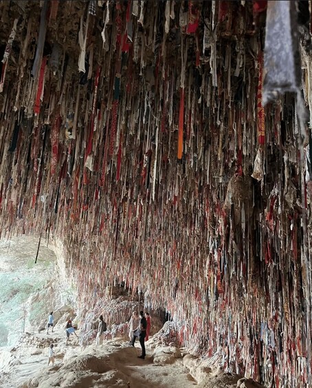 A cave with hanging fabrics and a person walking inside. 4
