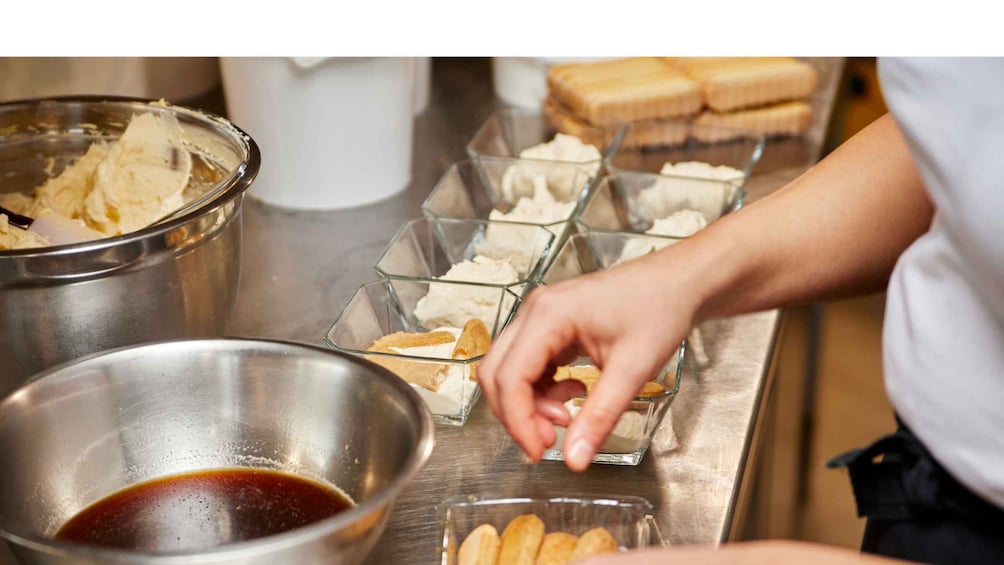 A person preparing food, with bowls of ingredients and a tray of food items. 5