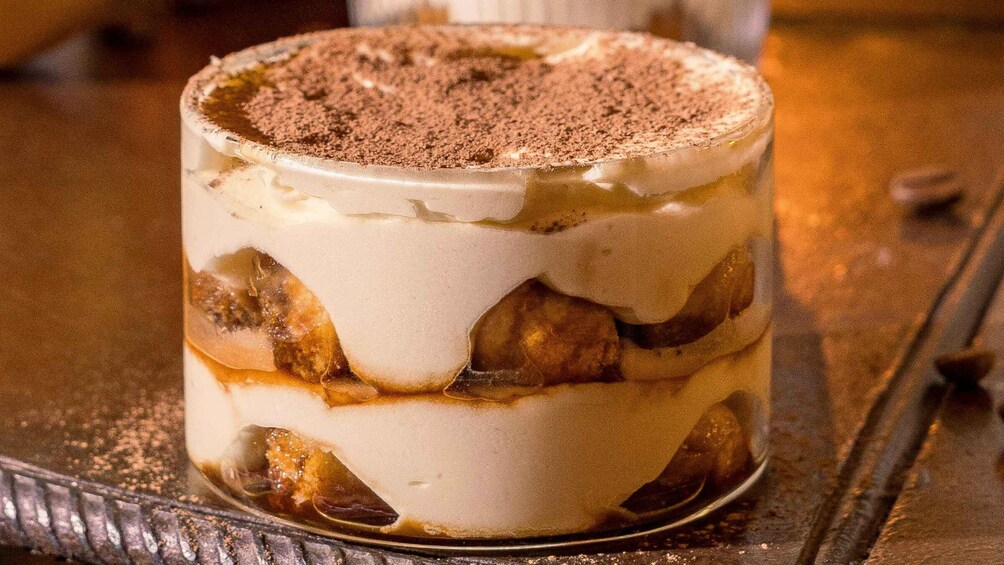 A layered dessert with a creamy top layer and a dusting of cocoa powder. 1